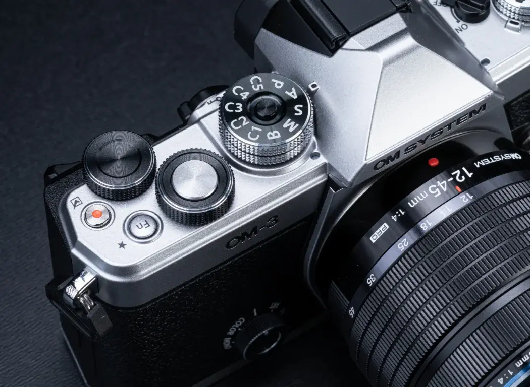 Image of the OM SYSTEM OM-3 showing a close up of the camera dials.